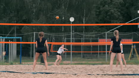 Women-Competing-in-a-Professional-Beach-Volleyball-Tournament.-A-defender-attempts-to-stop-a-shot-during-the-2-women-international-professional-beach-volleyball